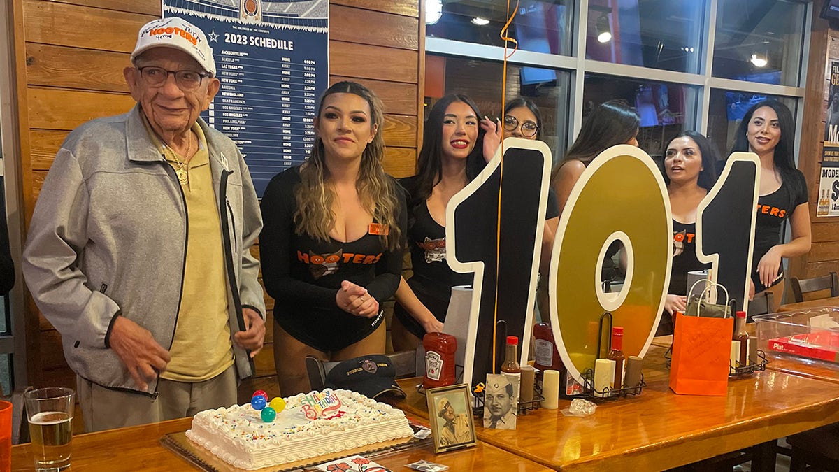 Man and Hooters Girls with 101 sign