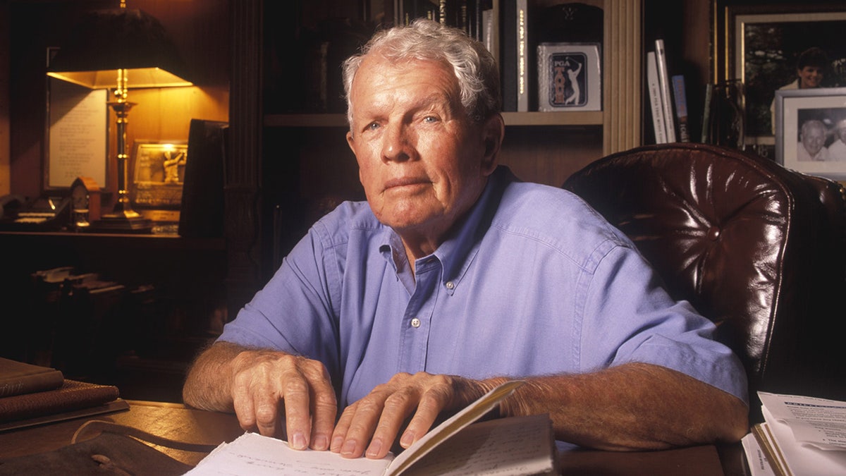 Jack Burke Jr. sits at desk reading book