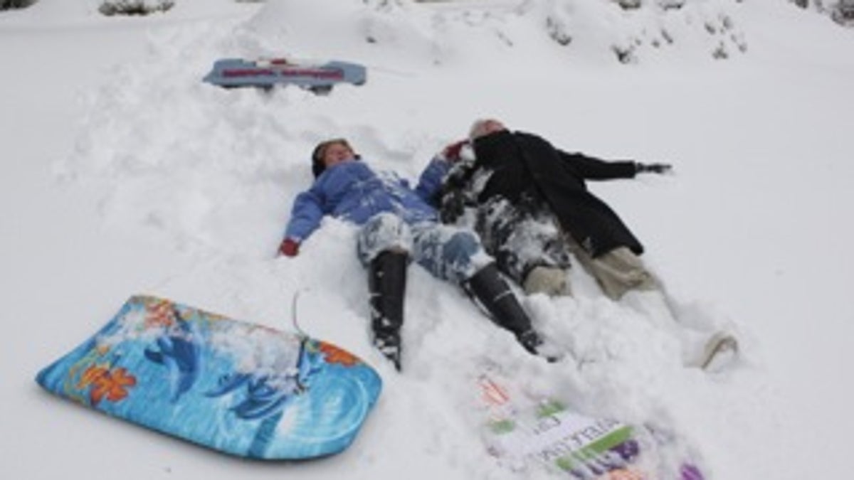 Married couple making snow angels