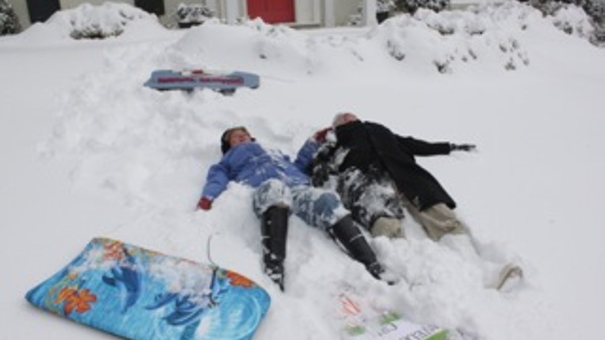 Married couple making snow angels