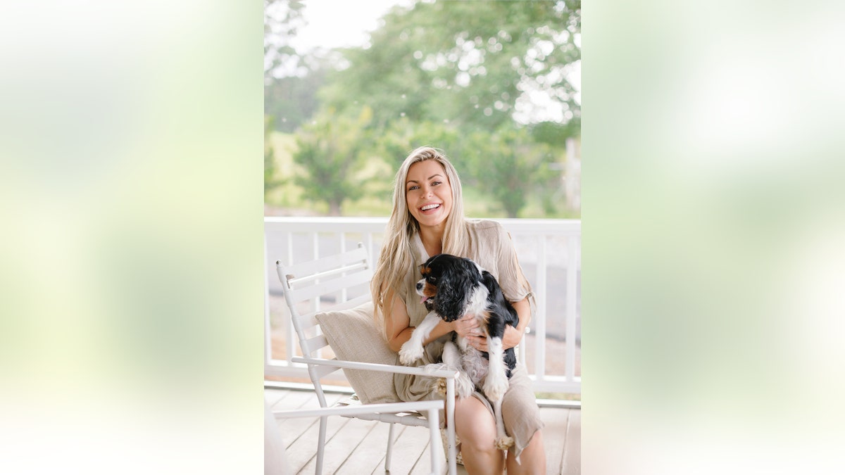 Crystal Hefner smiling and holding her dog