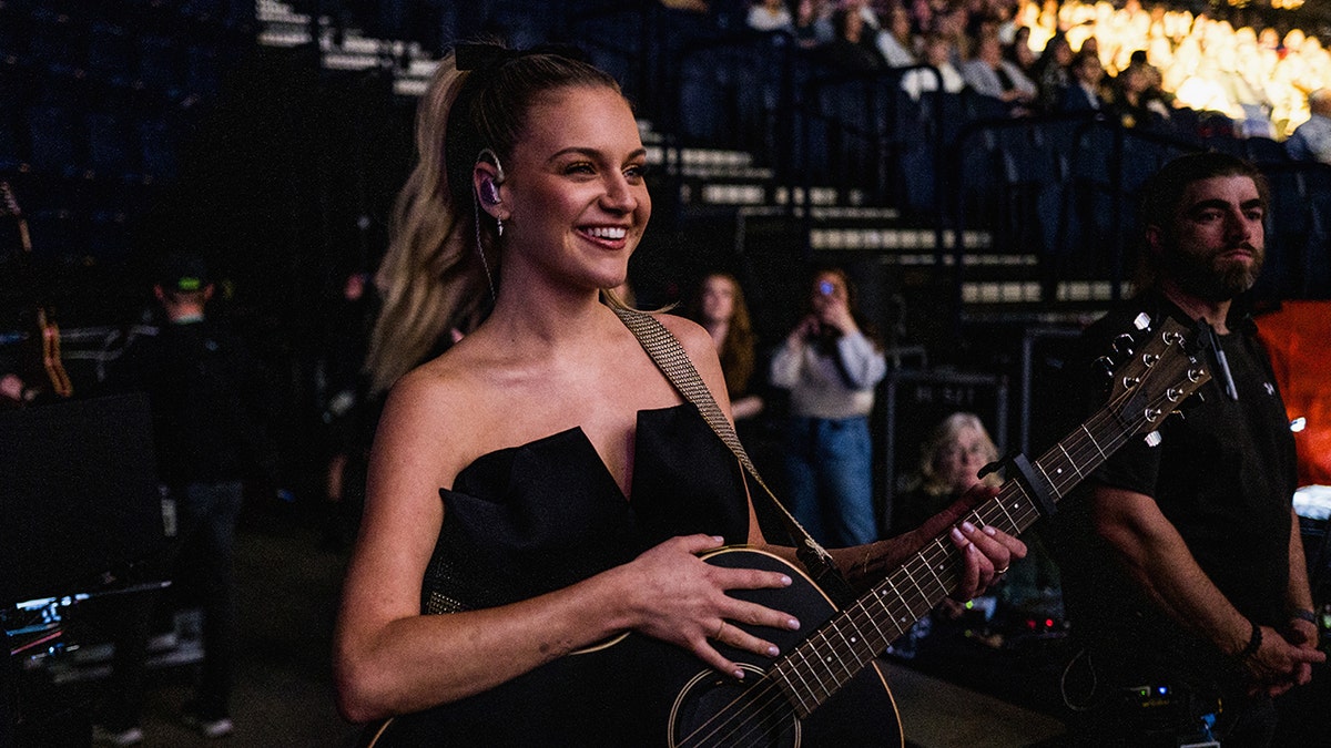 Kelsea Ballerini offstage with a guitar