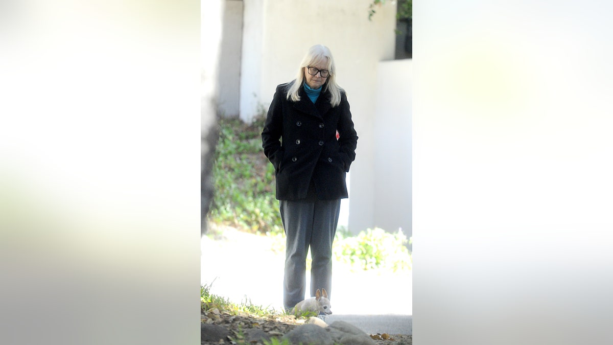 full length shot of shelley long looking down while on a walk