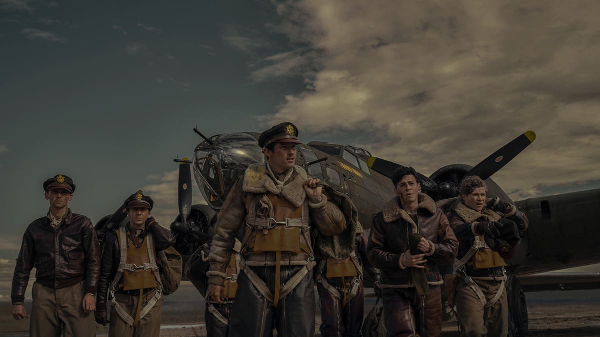 soldiers stand in front of plane in masters of the air