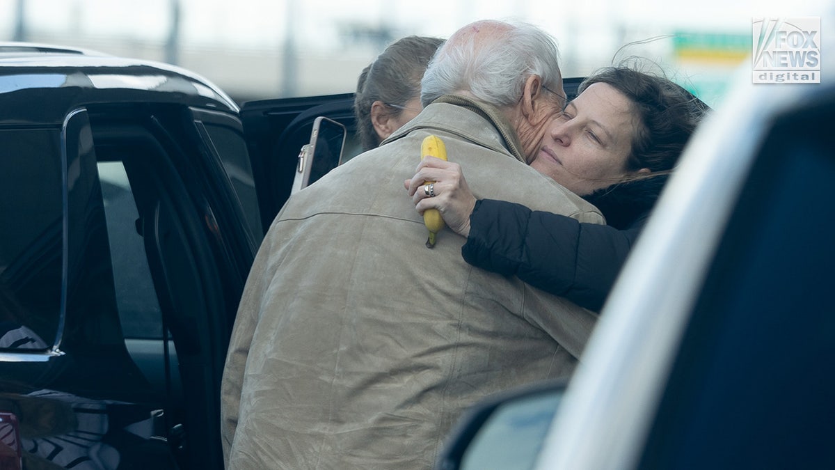 Michelle Troconis' father embraces a family member while dropping her off at John F. Kennedy International Airport