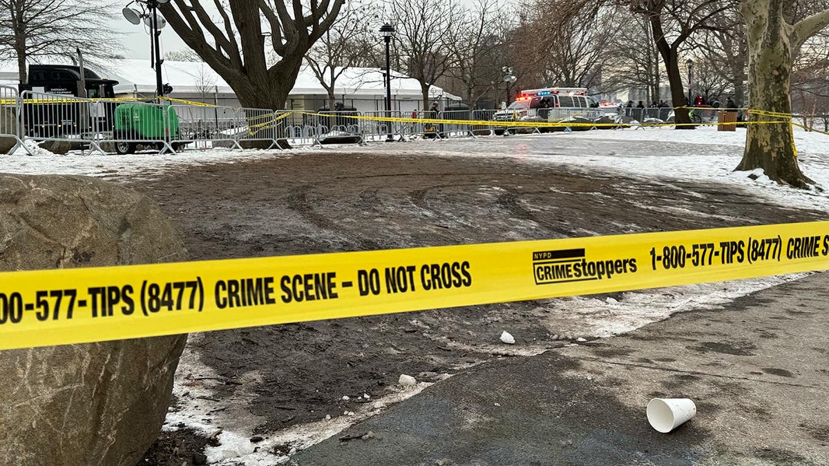 Police tape over the dirt and snow outside a migrant shelter on Randall's Island