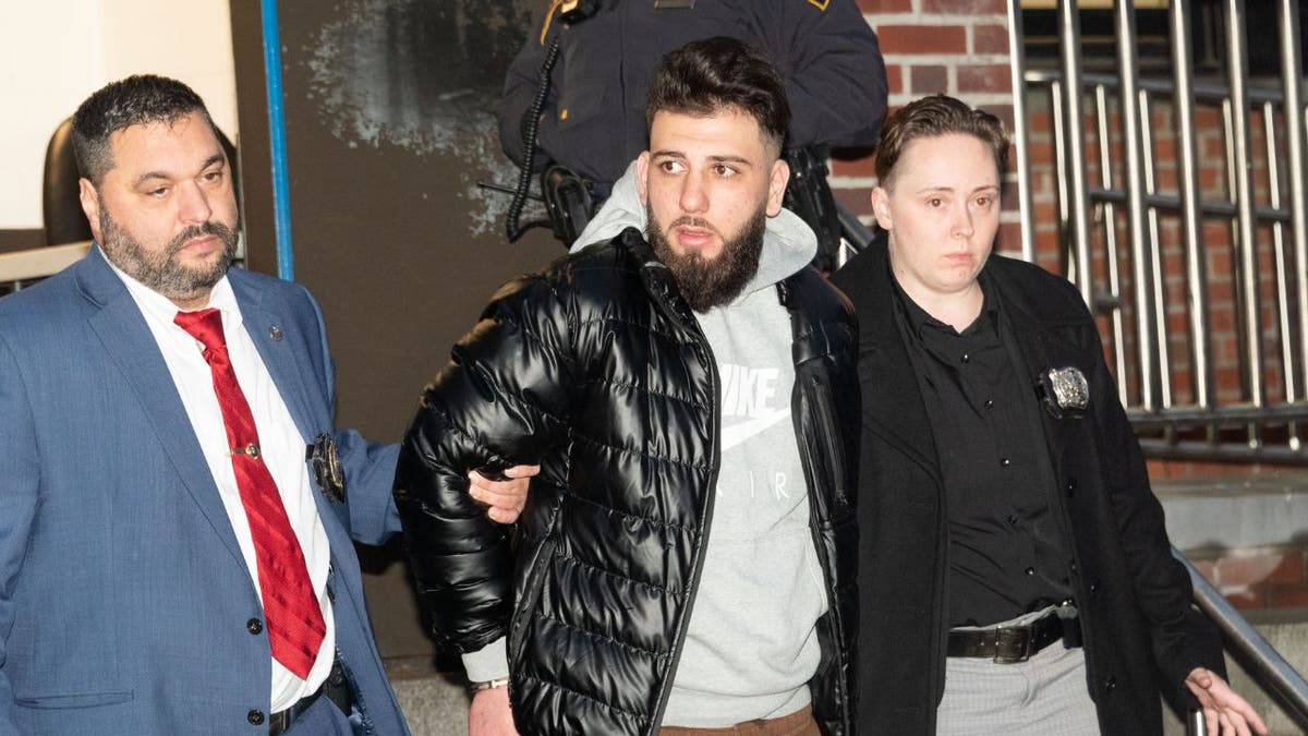 Mohammed Izzeddin, who has charged with rape, is perp walked flanked by two NYPD cops