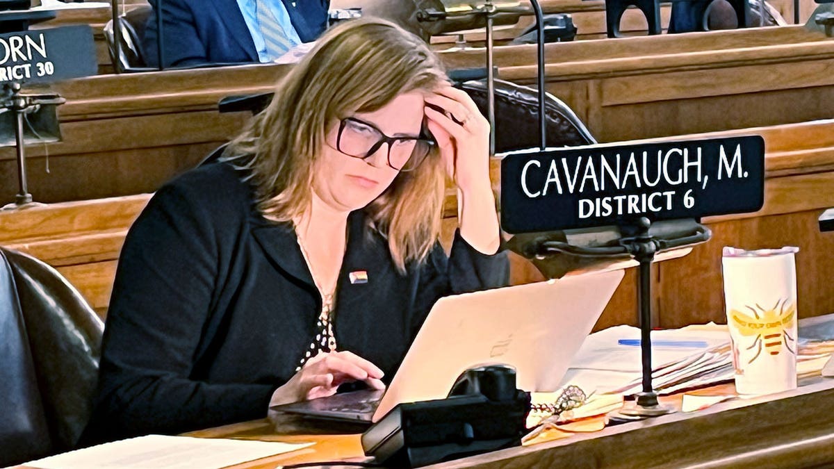 Nebraska state Sen. Machaela Cavanaugh sits at her desk in the Nebraska state Capital