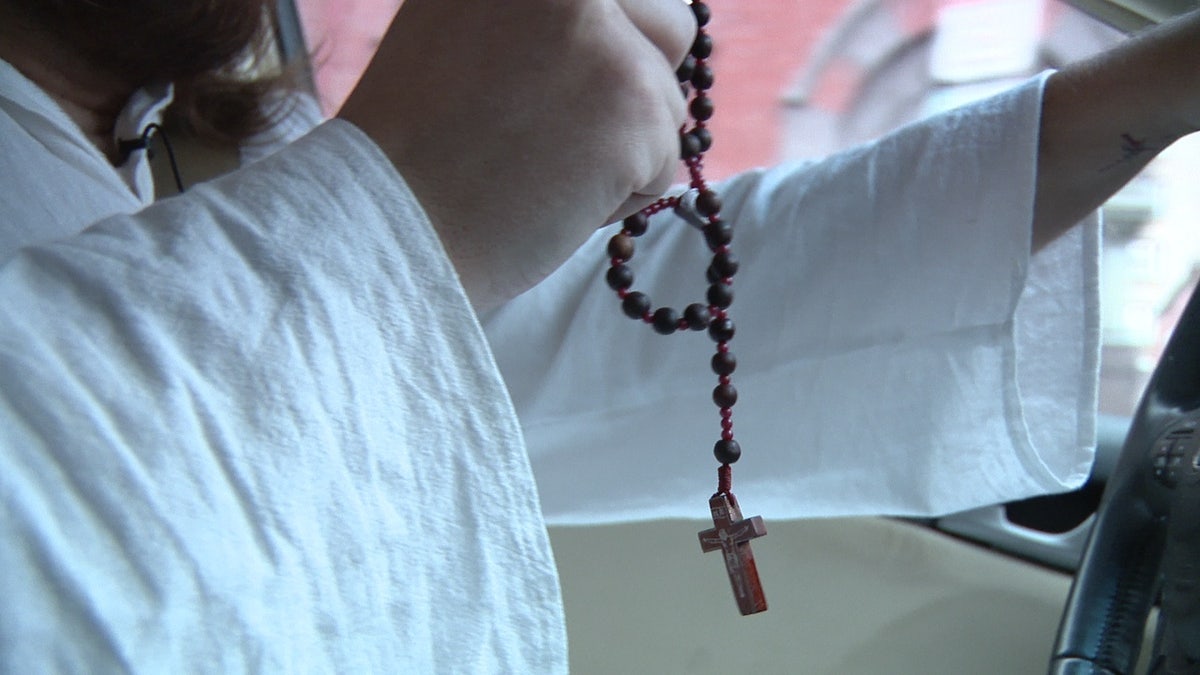 Rosary "Philly Jesus" holds while driving his Acura
