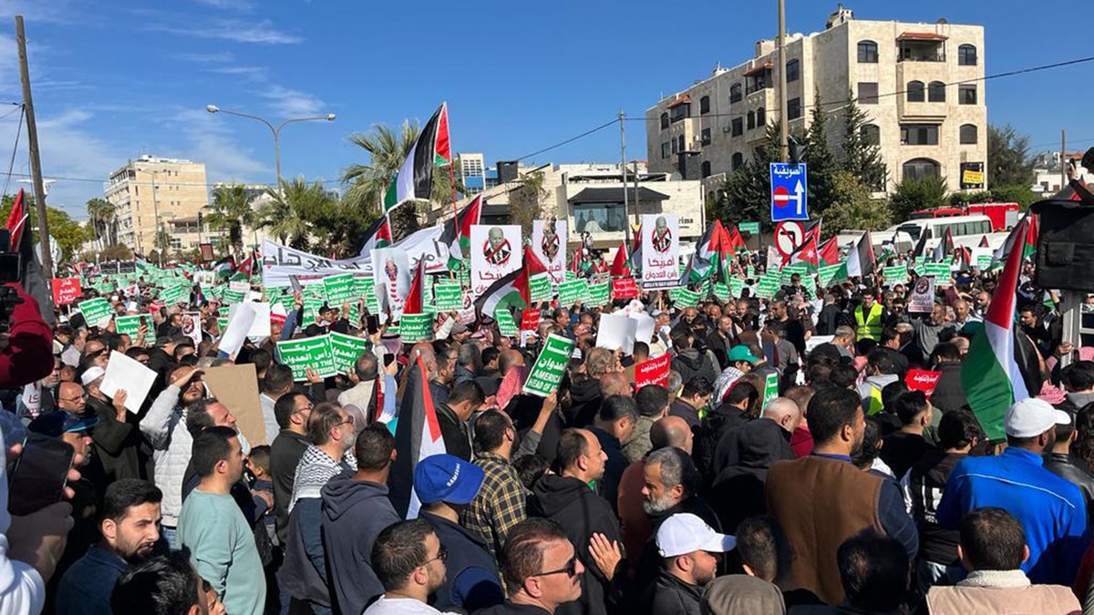 Pro-Palestinian protesters march with signs and Palestine flag