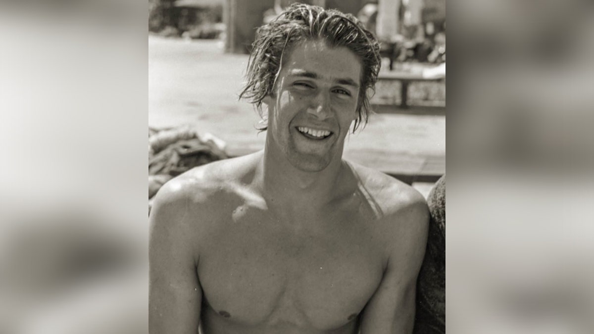 US Olympian swimmer and coach Richard Thornton pictured shirtless, smiling, at the beach in the summer of 1980 in black and white