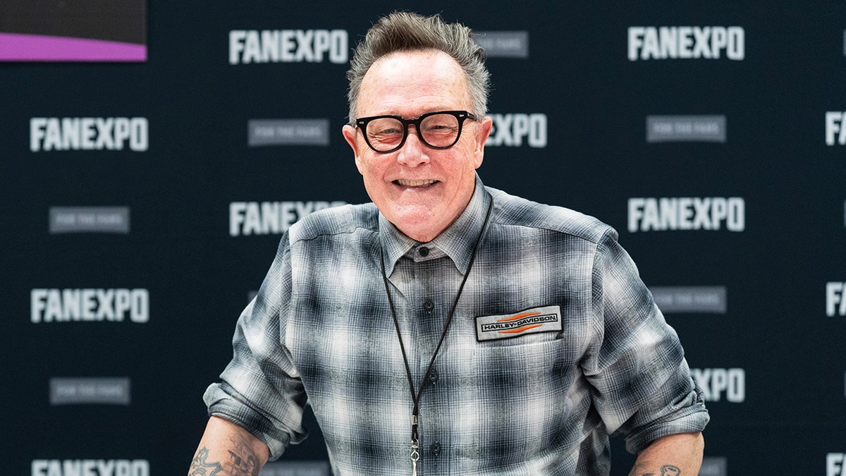 Robert Patrick posing at a table at a comic con