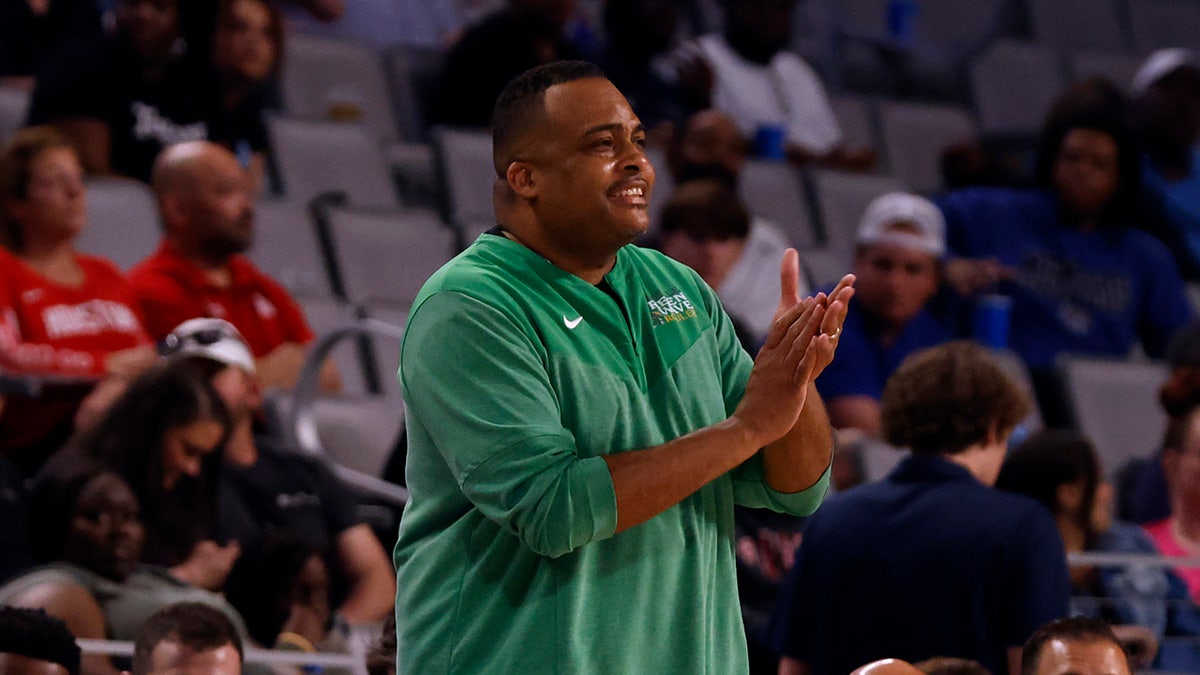 Ron Hunter applauds on the court