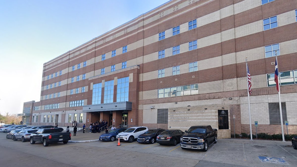 San Jacinto jail, cars in parking lot, American flag and Texas flag