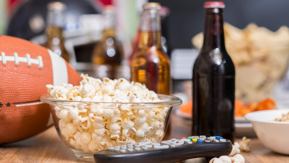 Popcorn, beer, a TV remote, and a football
