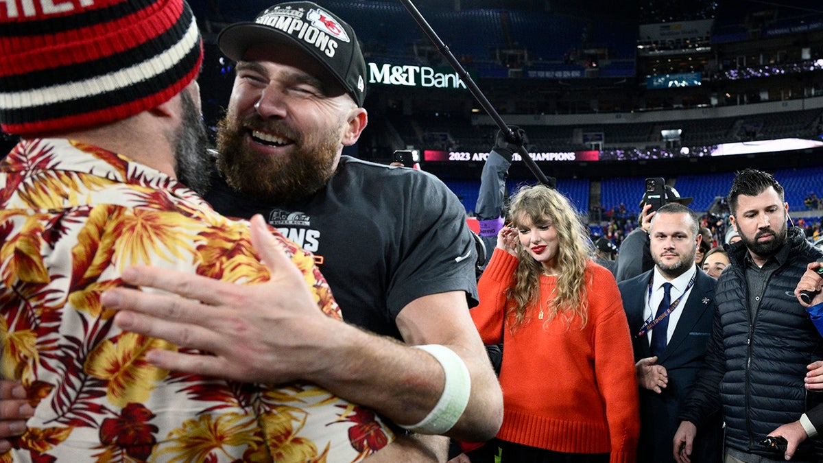 Jason Kelce embraces his brother Travis Kelce as Taylor Swift smiles