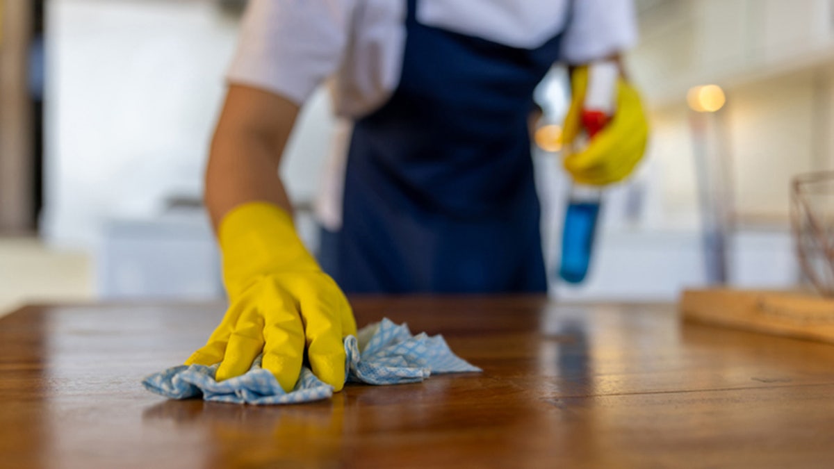 A person cleaning a counter.