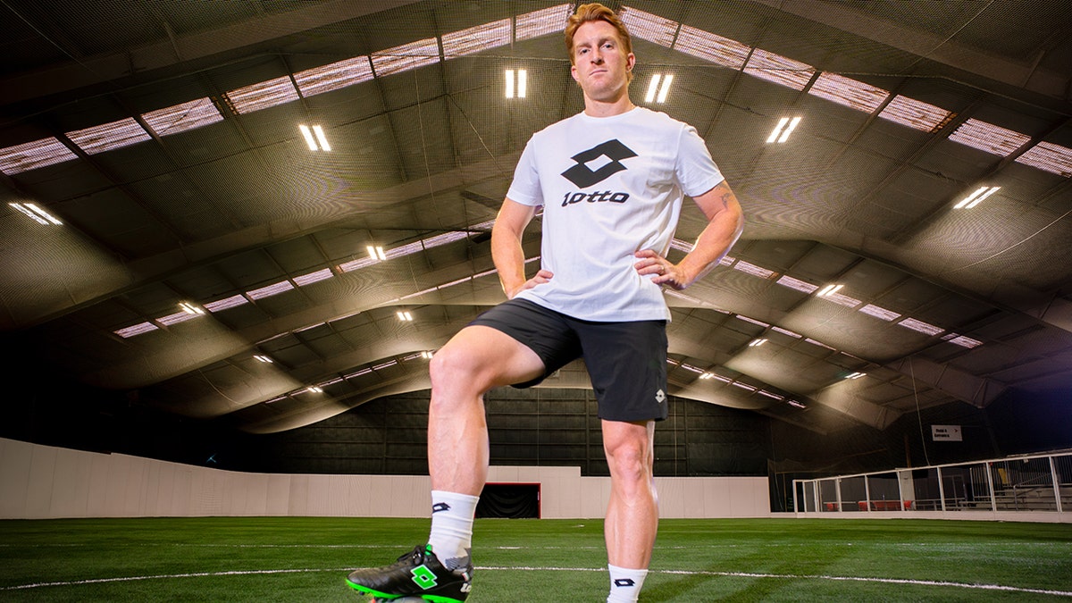 Tim parker poses for picture with soccer ball