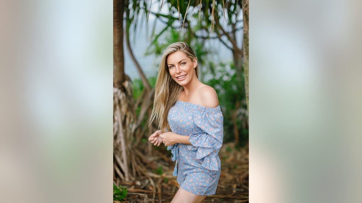 Crystal Hefner smiling in a blue off the shoulder dress