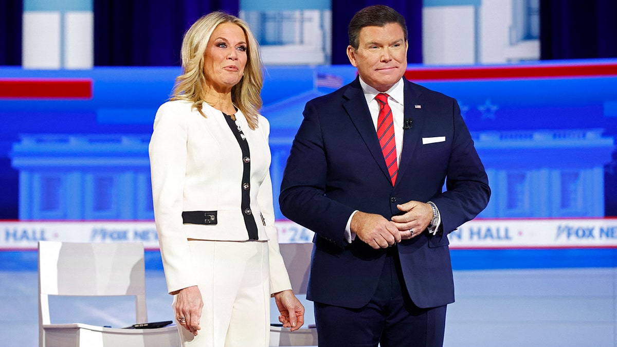 Fox News moderators Martha MacCallum in white jacket and pants (left) and Bret Baier in navy suit with red and blue thin striped tie (right)