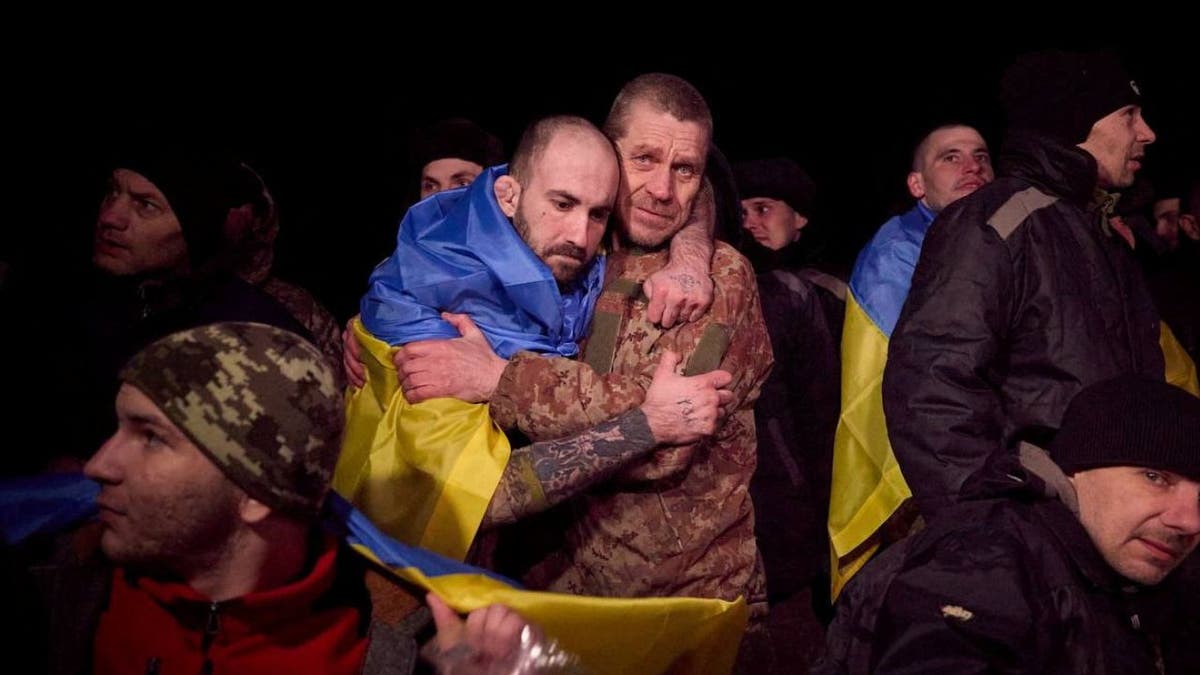 Two Ukrainian prisoners of war hug after a swap, amid Russia's attack on Ukraine, at an unknown location in Ukraine