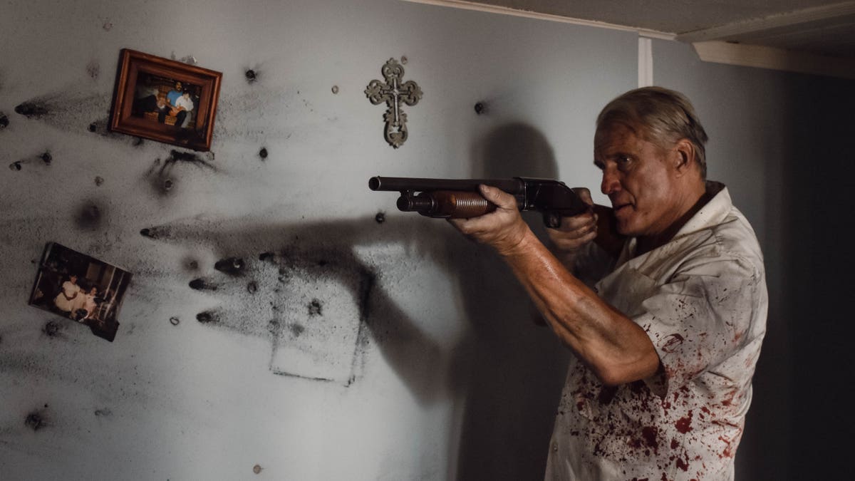 dolph lundgren holding a gun in blood-splattered clothes in wanted man