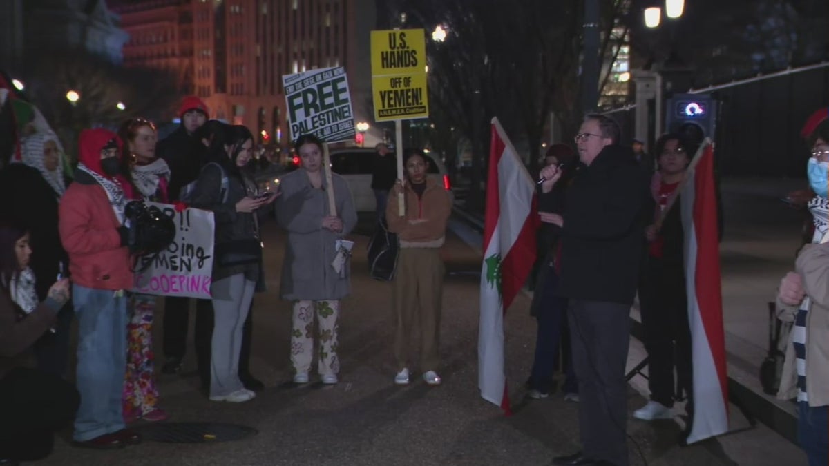 Protesters hold anti-war signs outside the White House