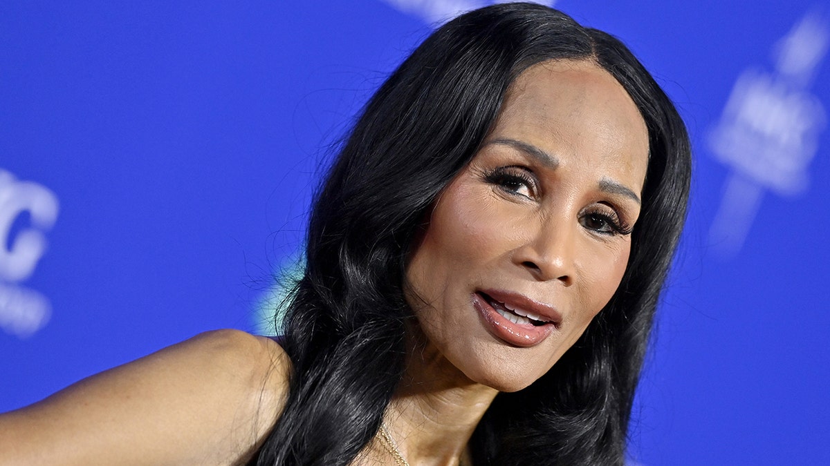 Beverly Johnson on the carpet in front of a blue backdrop