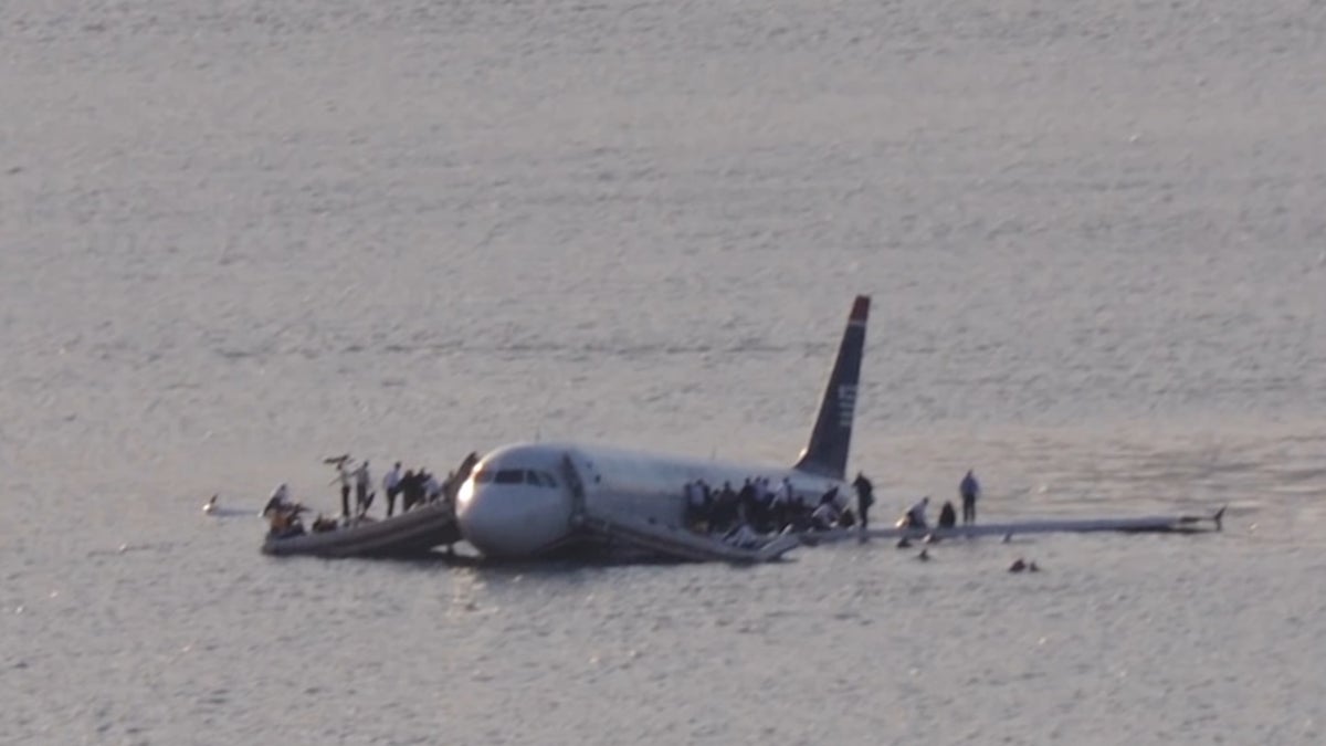 Airways Flight 1549 resting in the Hudson River as passengers stood on the wings waiting to be rescued