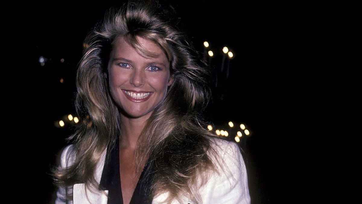 Christie Brinkley smiling in a white top