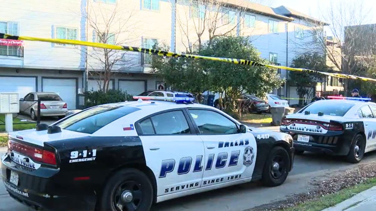 Police vehicles parked outside a home where a girl was shot dead