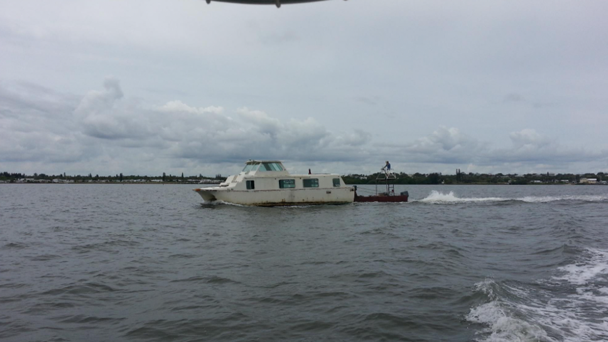 Derelict boat getting towed