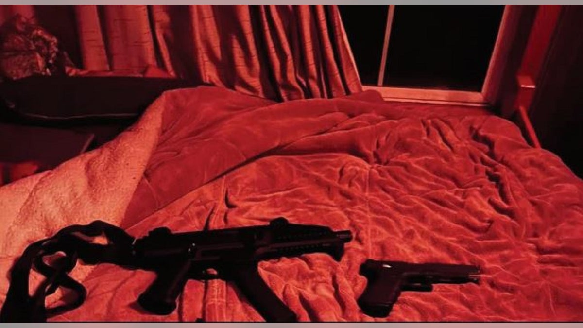 Two firearms on a bed