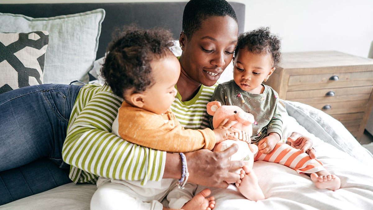 woman cuddling twins