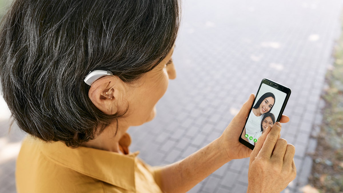 woman with hearing aid talks to family