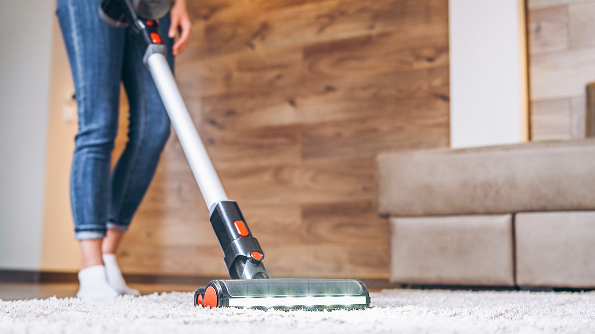 woman vacuums the floor