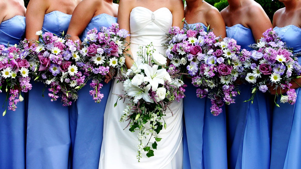 A bride's bouquet surrounded by her bridesmaids holding theirs. Vibrant colors.