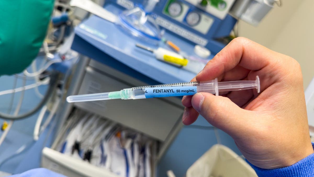 Nurse holding syringe labeled fentanyl 50 mcg/mL