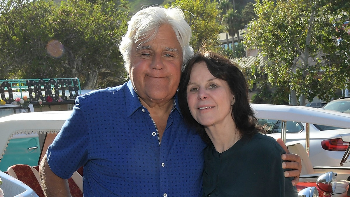 Jay Leno e sua esposa Mavis se abraçam em salão de automóveis em Malibu