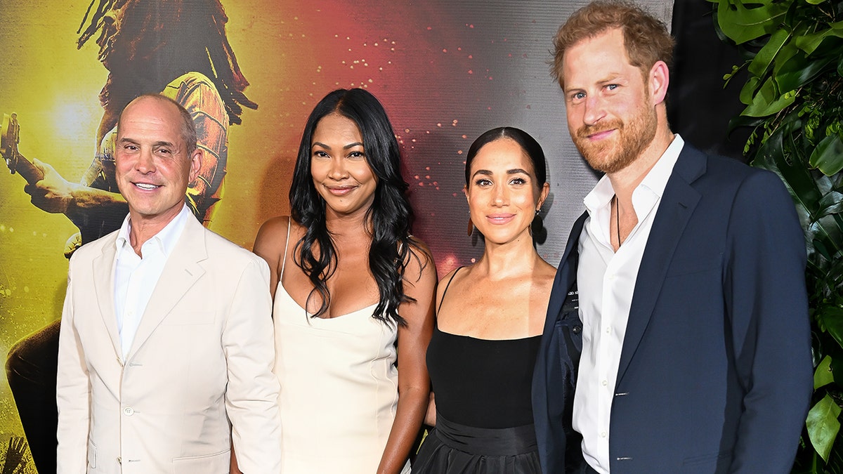 Prince Harry wears blue suit with Meghan Markle in black dress