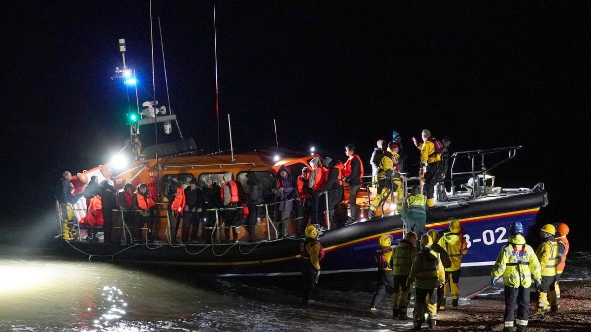 A lifeboat pulls ashore pinch rescued migrants