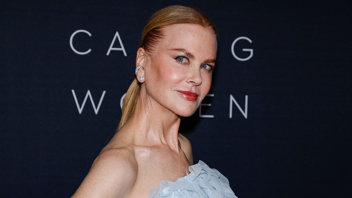 Nicole Kidman tilts her head slightly to the right in an upwards direction wearing a blue chiffon strapless dress