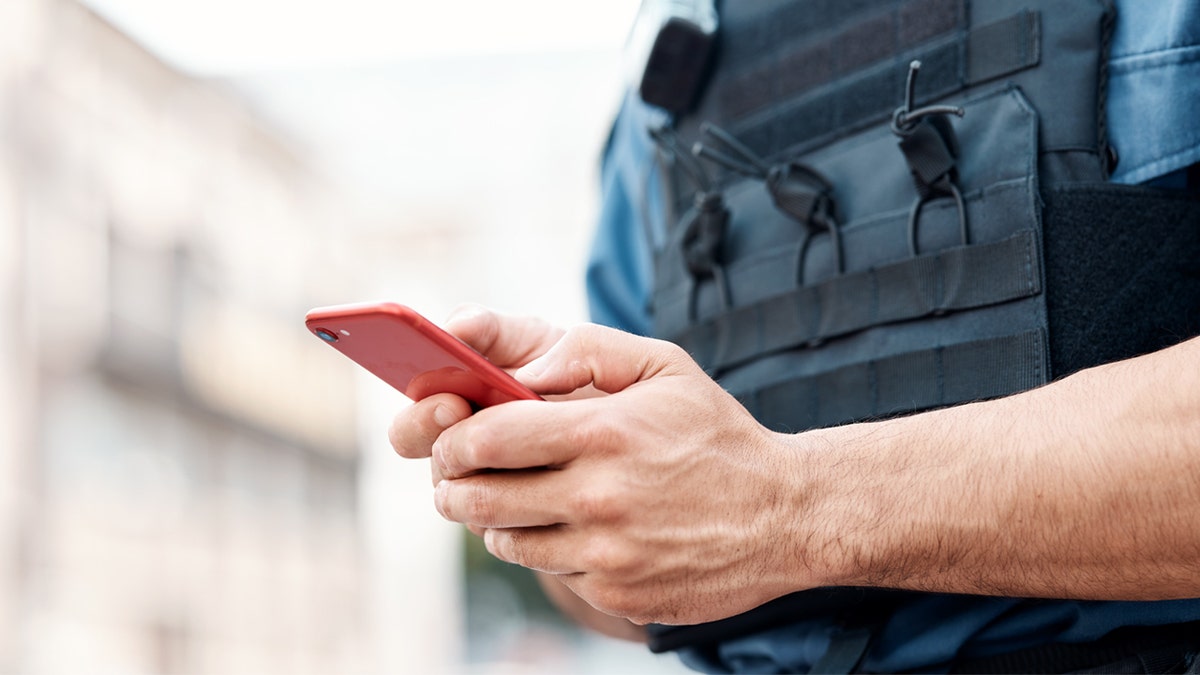 stock photo of police officer on a cellphone