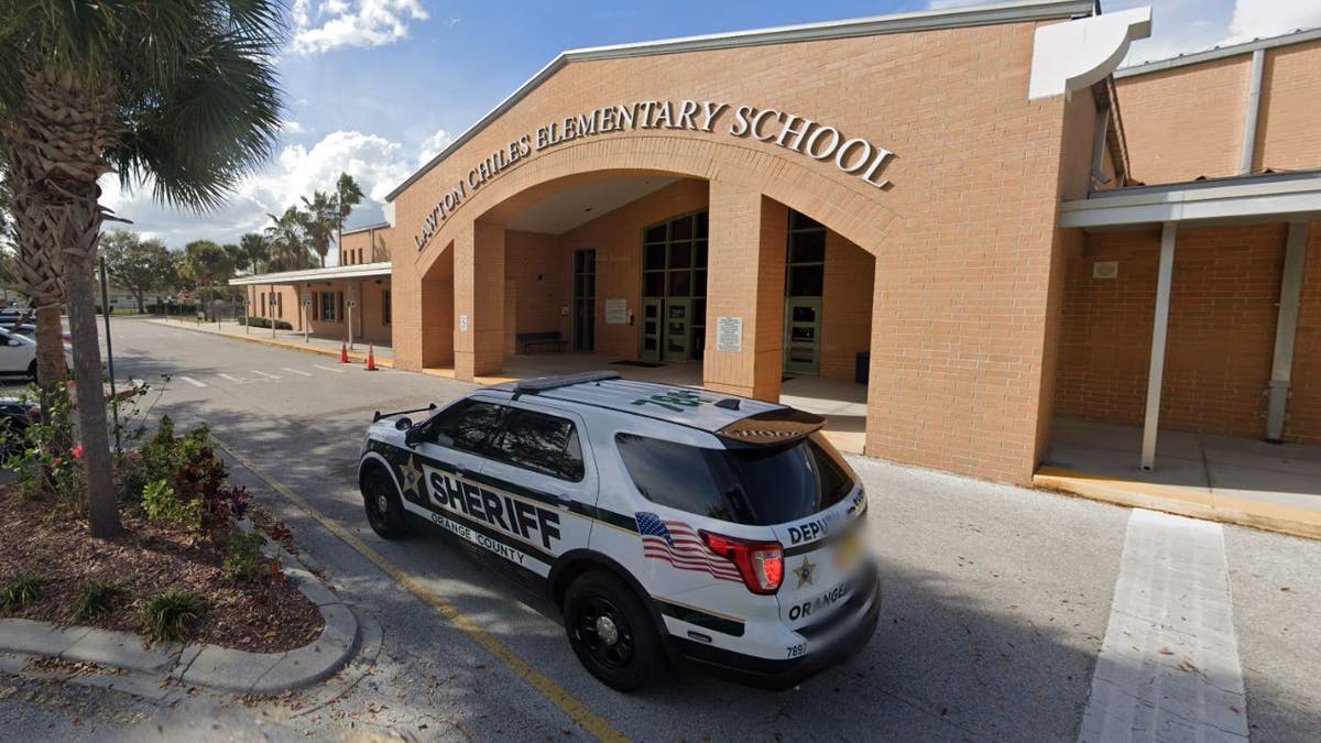 The entrance to  Lawton Chiles Elementary School with a police vehicle parked outside
