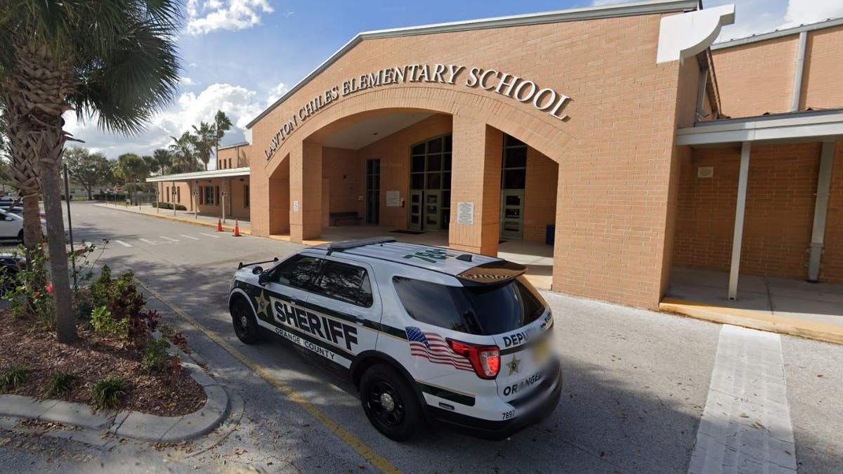 The entrance to Lawton Chiles Elementary School with a police vehicle parked outside