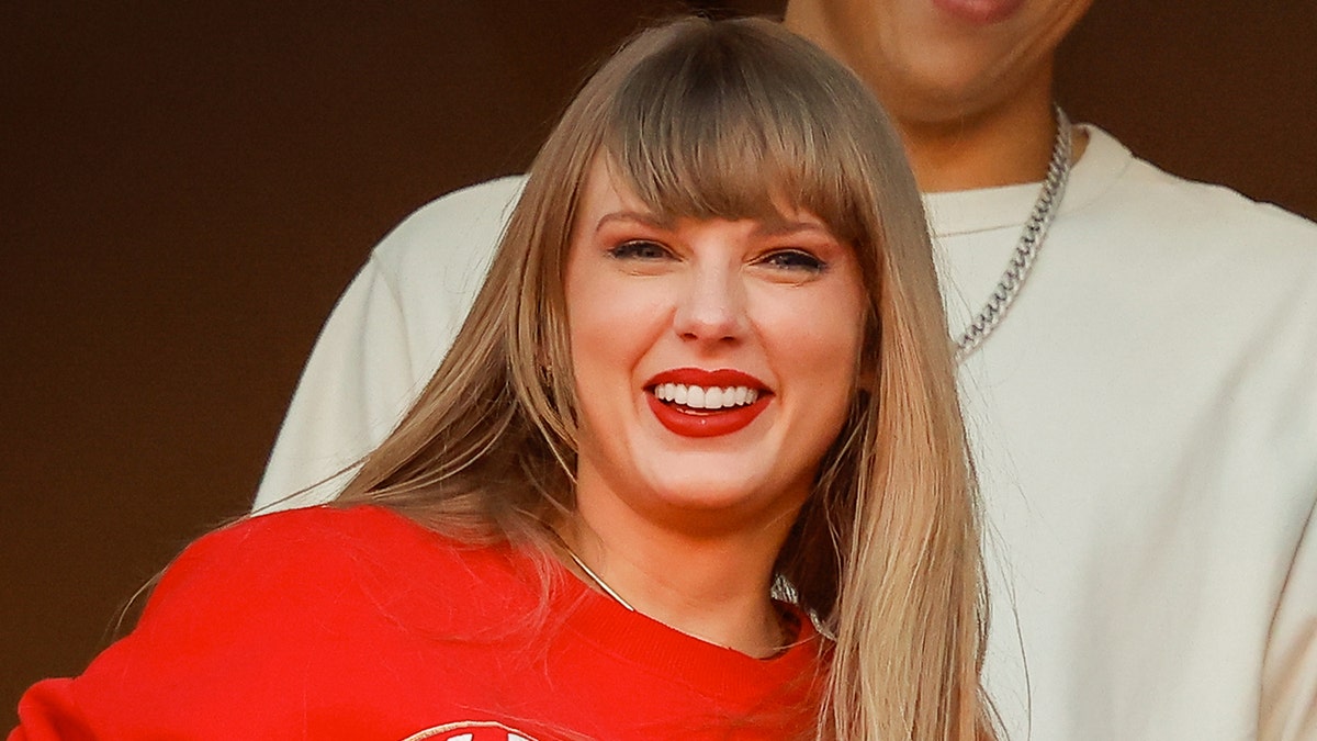 Taylor Swift sorri durante jogo de futebol americano do Kansas City Chiefs com Travis Kelce