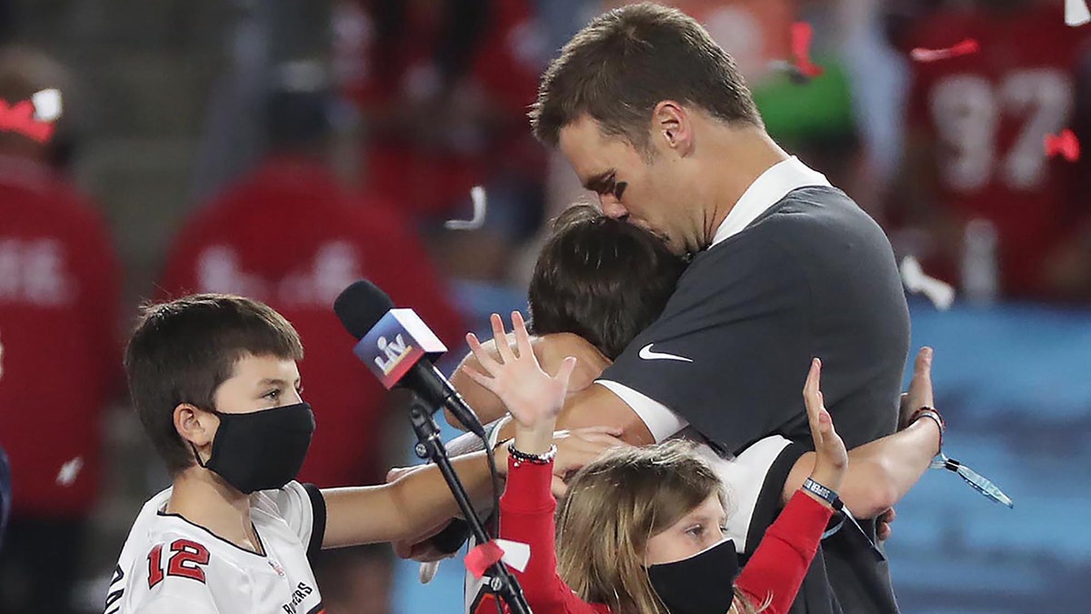 Tom Brady hugs his eldest son Jack with his kids Benjamin and Vivian, celebrating the Tampa Bay Buccaneer's Super Bowl win 