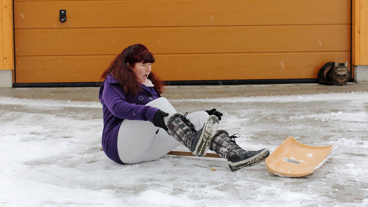 Woman falling while shoveling snow