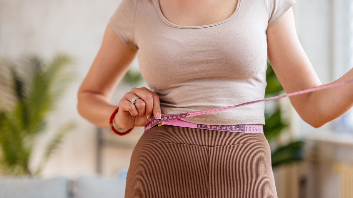 woman measuring waist