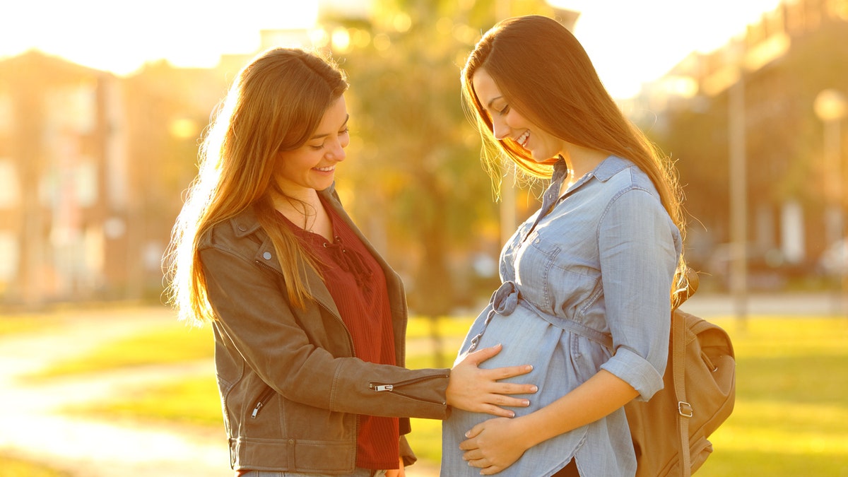 Woman touching pregnant belly